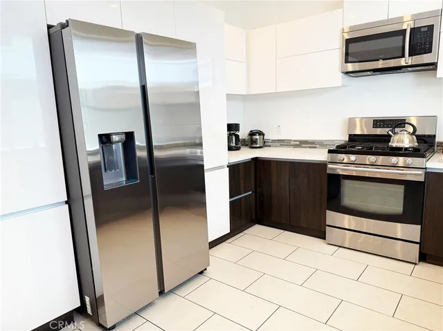 a kitchen with stainless steel appliances granite countertop a stove a refrigerator and a microwave