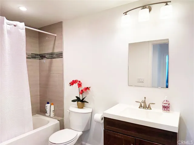 a bathroom with a sink vanity mirror and toilet