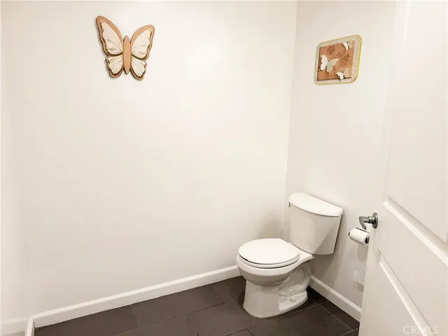 a white toilet sitting next to a white wall