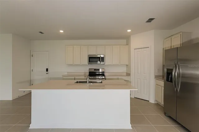 a kitchen with stainless steel appliances granite countertop a refrigerator and a stove
