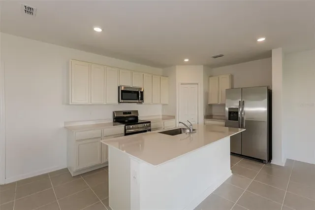 a kitchen with stainless steel appliances a refrigerator sink and microwave