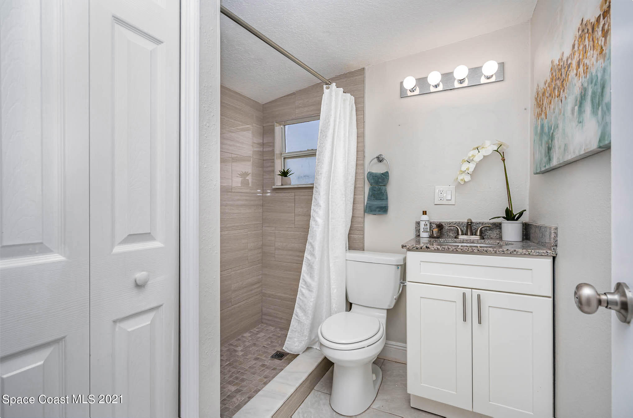 2210 Allan Adale Road Melbourne, FL 32935 - Photo 13 of 23 a bathroom with a toilet a sink and shower