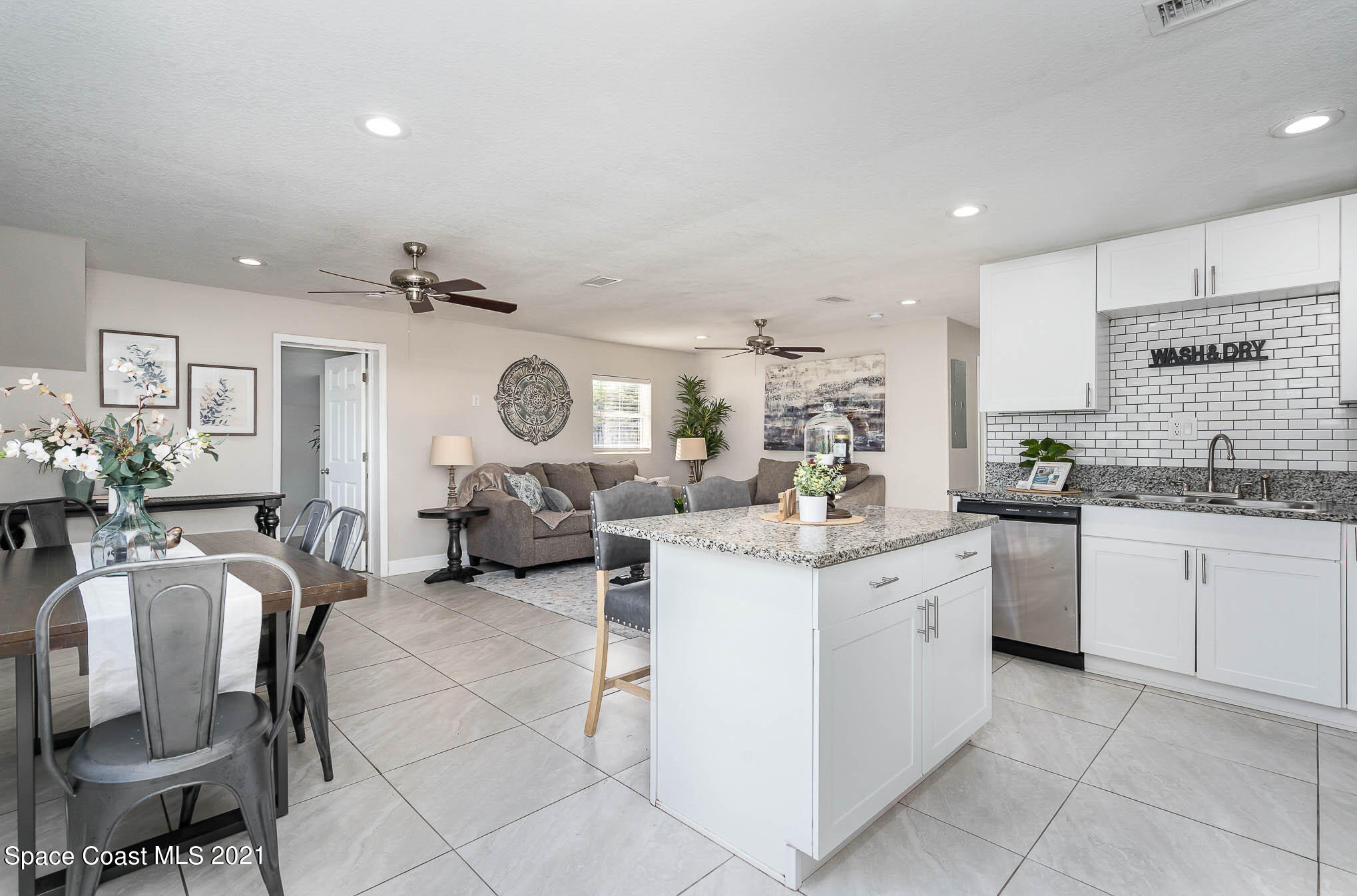 2210 Allan Adale Road Melbourne, FL 32935 - Photo 9 of 23 a very nice looking dining room with kitchen island stainless steel appliances furniture a large window and a sink