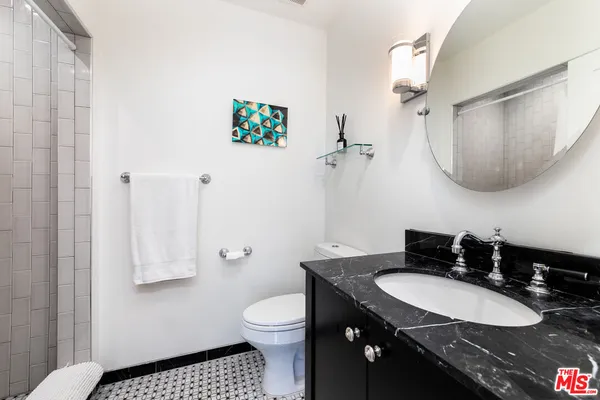 a bathroom with a sink a toilet and mirror