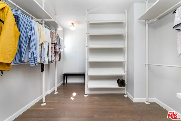 a view of walk in closet with clothes and shoes
