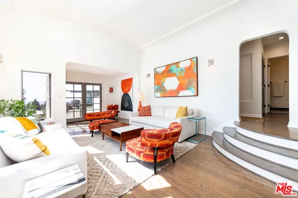 a living room with furniture and a floor to ceiling window
