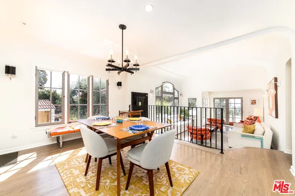 a dining room with furniture a chandelier and wooden floor