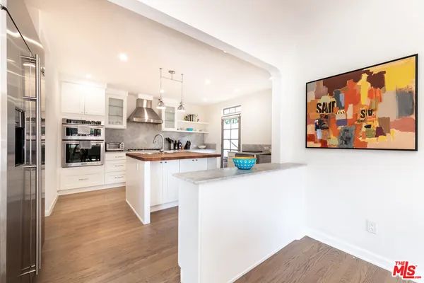 a kitchen with stainless steel appliances a refrigerator and a stove top oven