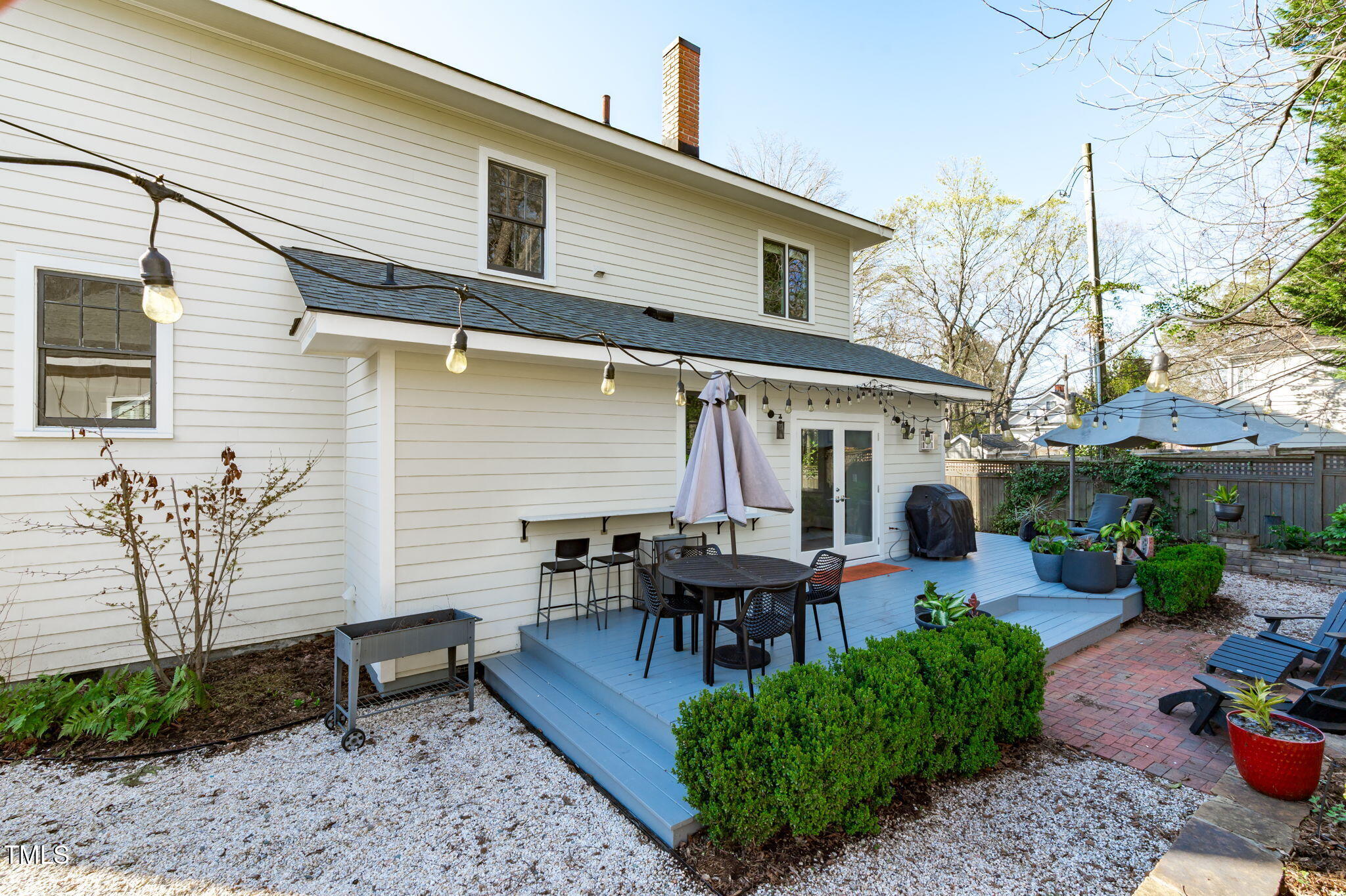 202 Duncan Street Raleigh, NC 27608 - Photo 33 of 46 a view of a patio with table and chairs potted plants and large tree