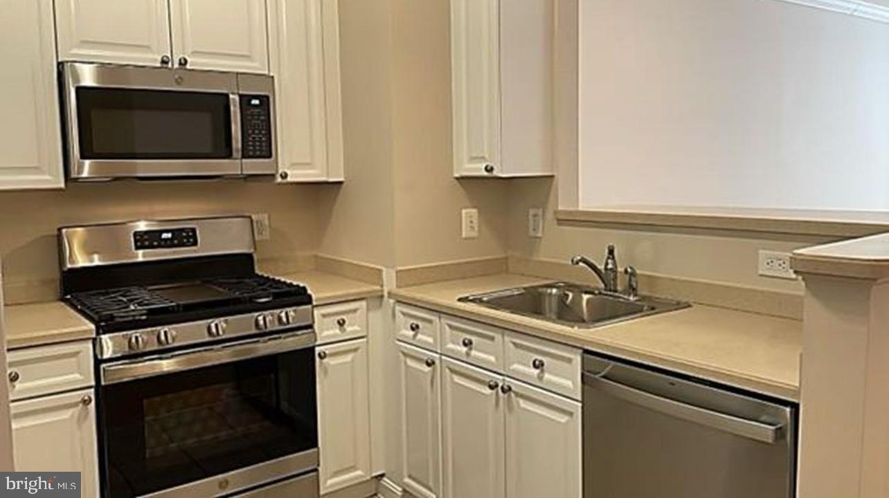 9480 Virginia Center Boulevard, Unit 119 Vienna, VA 22181 - Photo 1 of 17 a kitchen with stainless steel appliances granite countertop a stove microwave and sink
