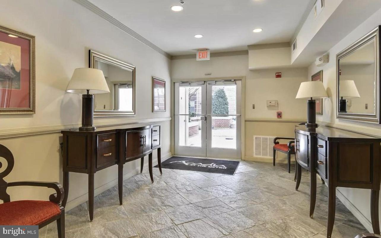 9480 Virginia Center Boulevard, Unit 119 Vienna, VA 22181 - Photo 16 of 17 a living room with furniture a fireplace and a chandelier
