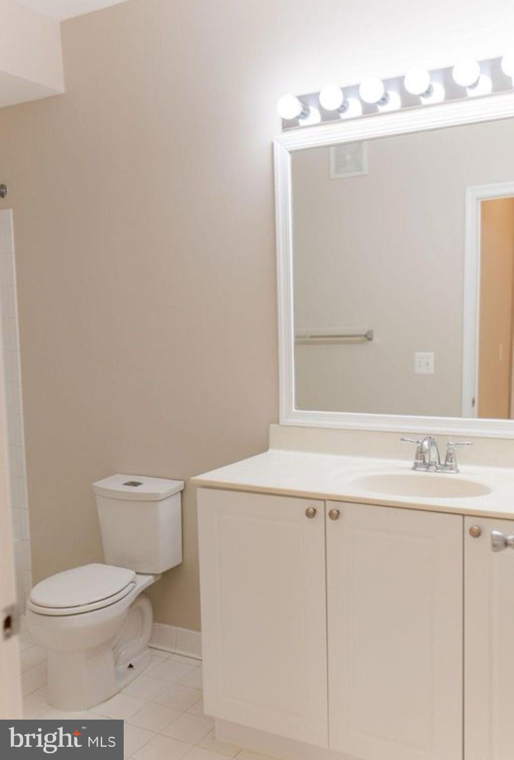 9480 Virginia Center Boulevard, Unit 119 Vienna, VA 22181 - Photo 2 of 17 a bathroom with a sink a toilet and a mirror