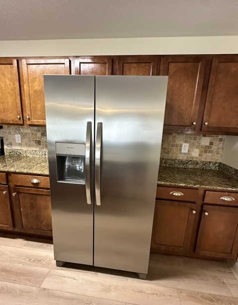 203 Kelly Road, Unit 714 Clemson, SC 29631 - Photo 8 of 12 A well-equipped kitchen features ample cabinetry, granite counters, and a sleek stainless steel refrigerator.