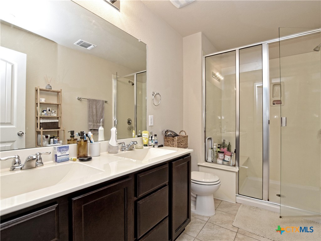 516 East Slaughter Lane, Unit 1801 Austin, TX 78744 - Photo 16 of 30 a bathroom with a double vanity sink toilet and shower