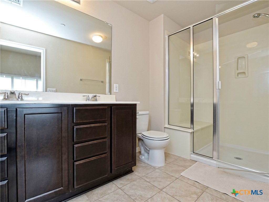 516 East Slaughter Lane, Unit 1801 Austin, TX 78744 - Photo 20 of 30 a bathroom with a toilet a sink and shower