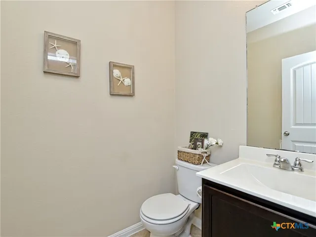 a bathroom with a sink a toilet and a mirror