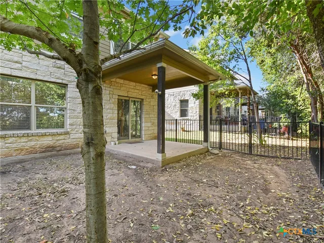 a view of a house with a small yard and large tree