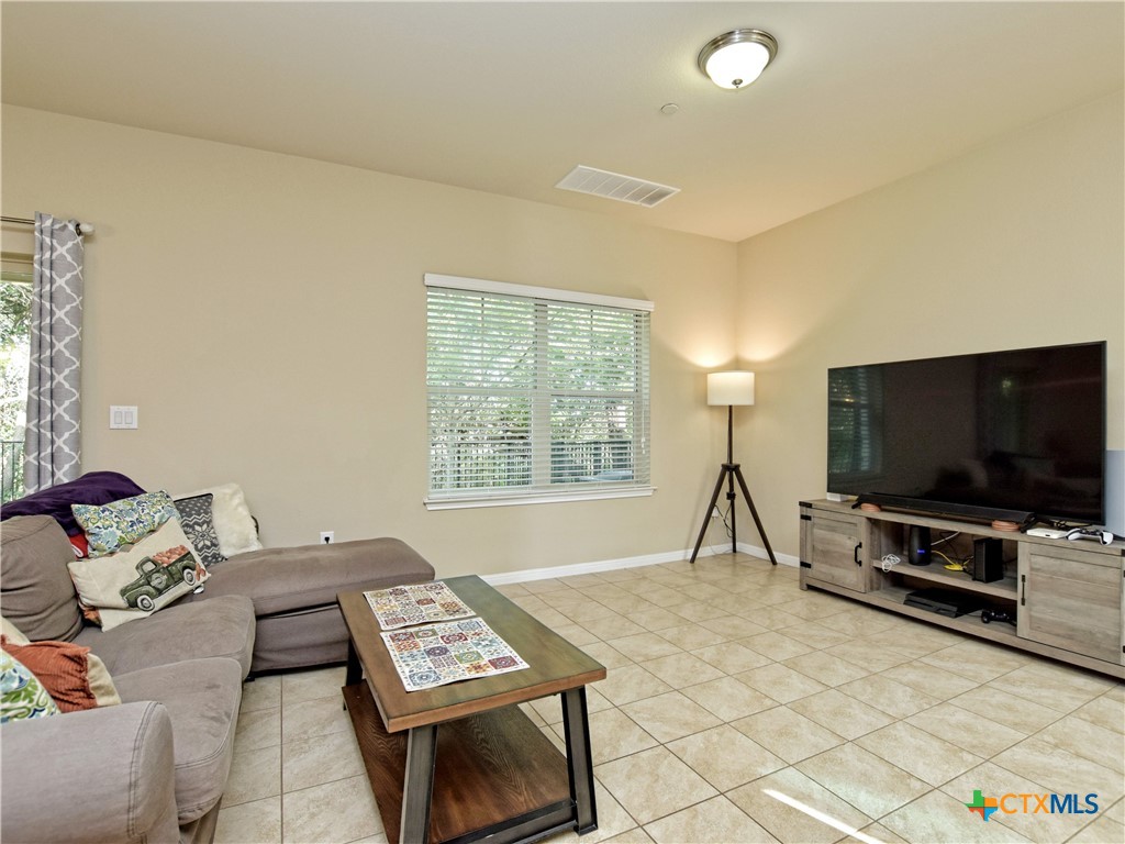 516 East Slaughter Lane, Unit 1801 Austin, TX 78744 - Photo 6 of 30 a living room with furniture and a flat screen tv