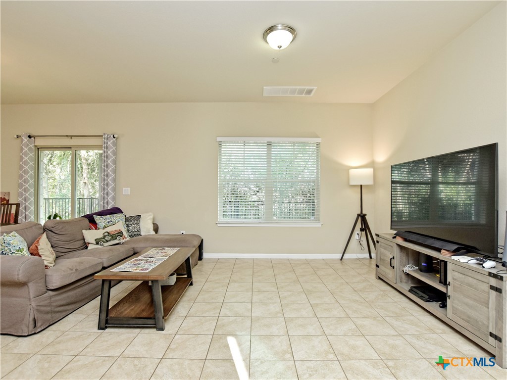 516 East Slaughter Lane, Unit 1801 Austin, TX 78744 - Photo 7 of 30 a living room with furniture and a flat screen tv