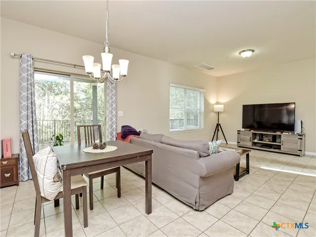 a living room with furniture a flat screen tv and a large window