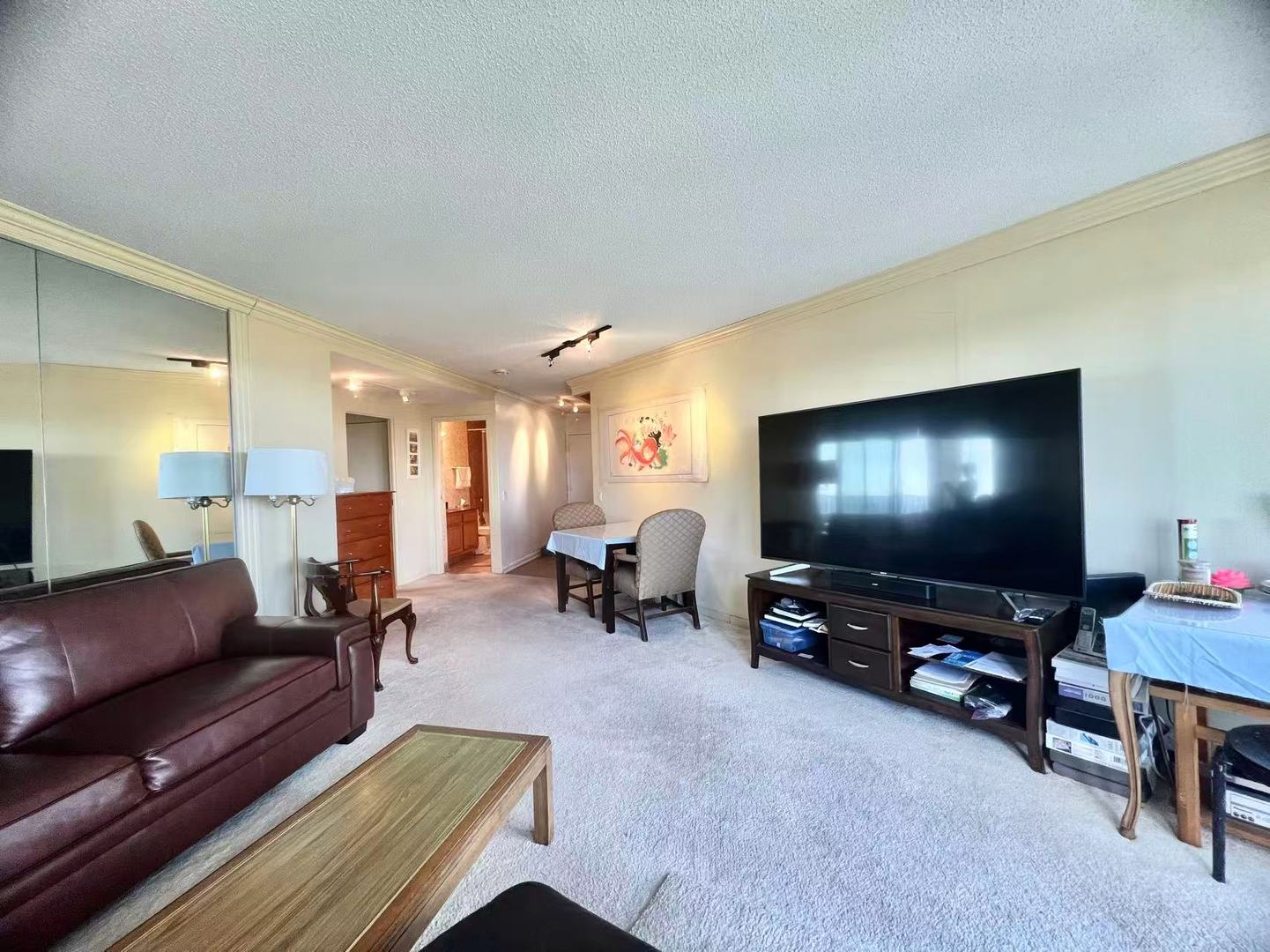 5320 North Sheridan Road, Unit 2203 Chicago, IL 60640 - Photo 10 of 27 a living room with furniture and a flat screen tv