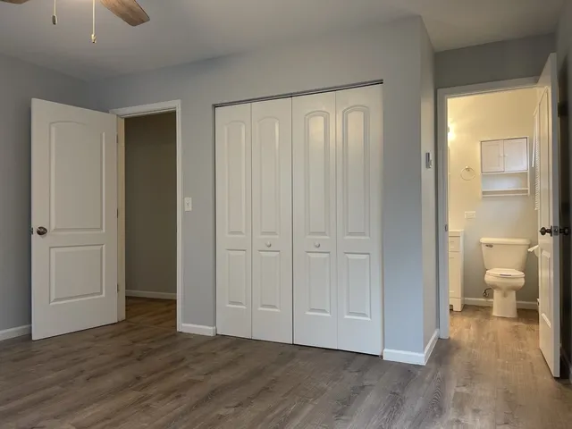 a view of a room with wooden floor and a bathroom