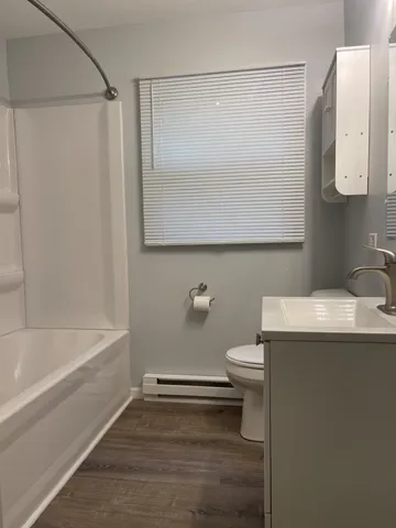a bathroom with a granite countertop sink mirror vanity and toilet