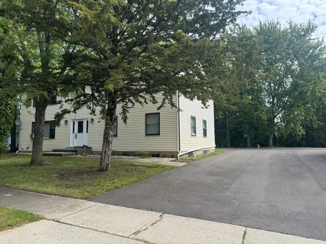 a white house that has a tree in front of it