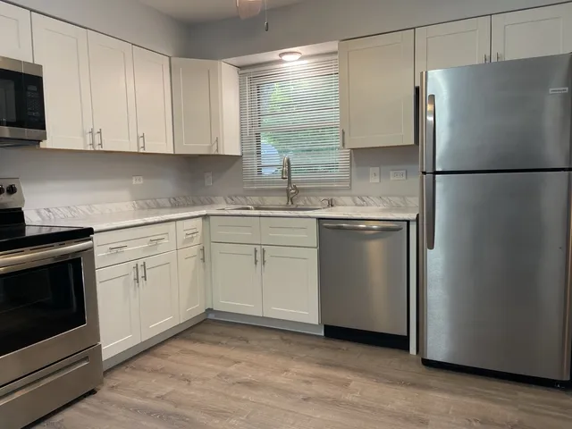 a kitchen with a sink stainless steel appliances and white cabinets