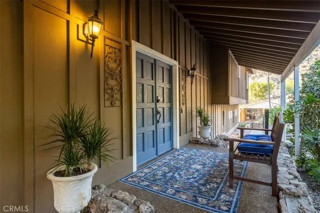 a view of a porch with chairs and potted plants