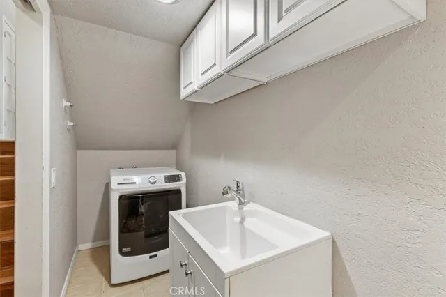 a living room with furniture a chandelier and a flat screen tv