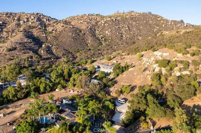 a view of a swimming pool with a bench and trees in the background