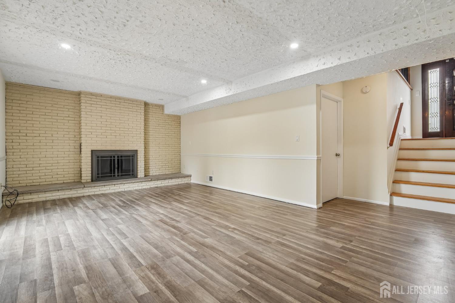 2 Marc Court Edison, NJ 08820 - Photo 15 of 23 an empty room with wooden floor and a fireplace