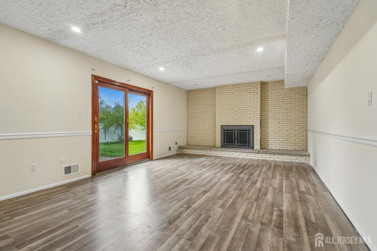 2 Marc Court Edison, NJ 08820 - Photo 16 of 23 an empty room with wooden floor and a fireplace