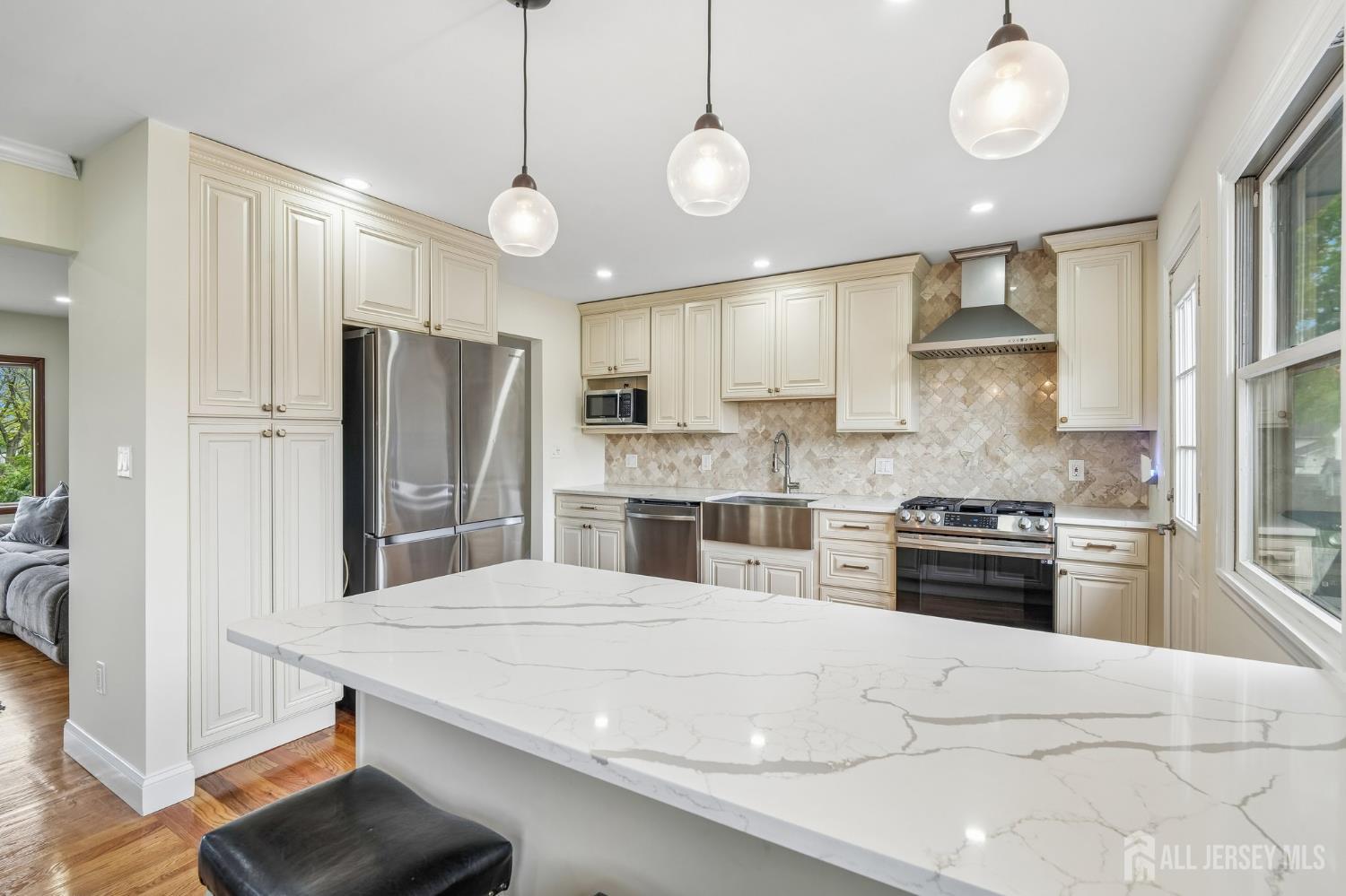 2 Marc Court Edison, NJ 08820 - Photo 10 of 23 a kitchen with stainless steel appliances kitchen island granite countertop a stove a refrigerator a oven a sink with a dining table and chairs