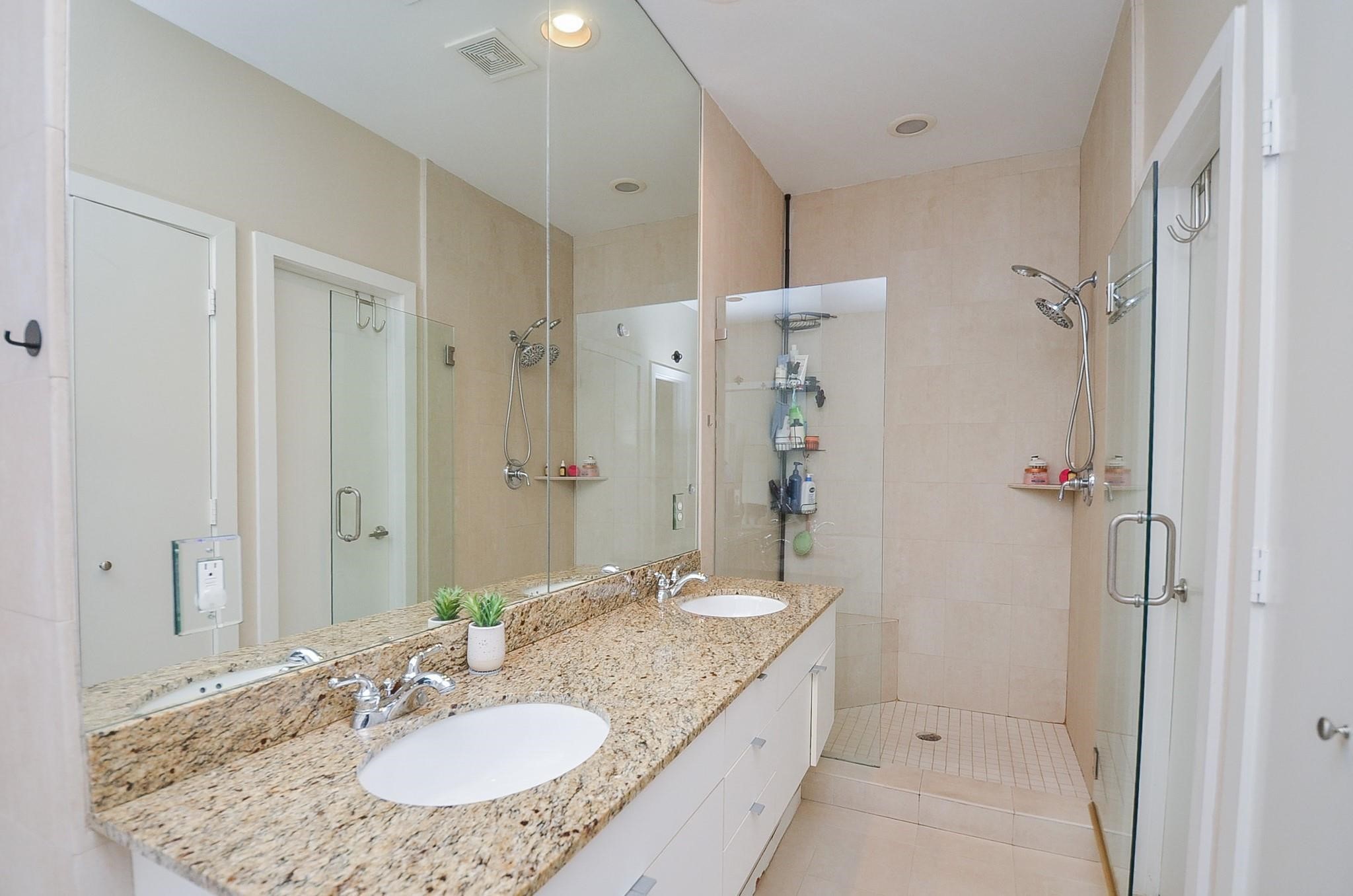 1116 Columbus Street Houston, TX 77019 - Photo 21 of 32 a bathroom with a granite countertop sink a mirror and a shower