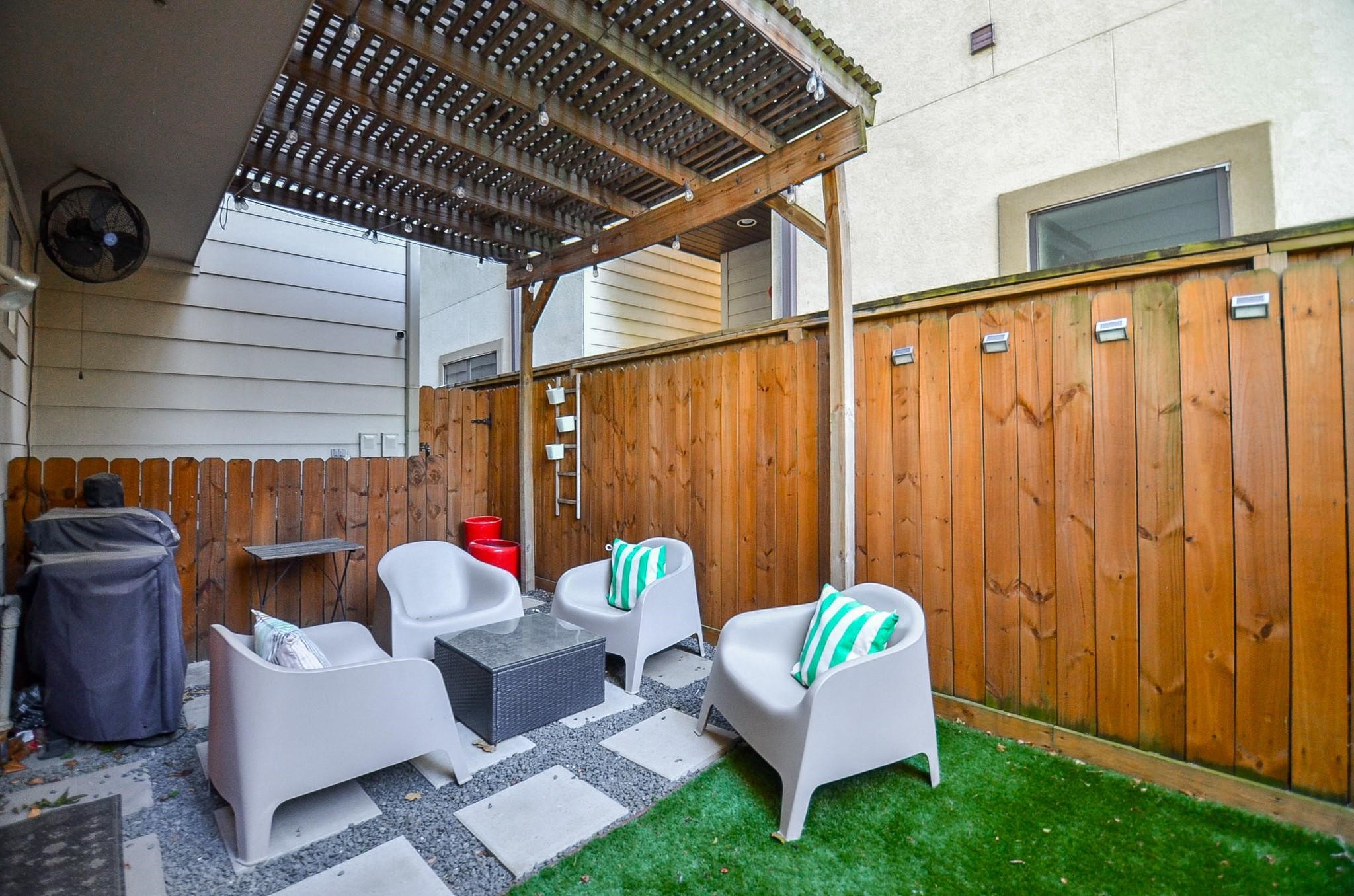 1116 Columbus Street Houston, TX 77019 - Photo 31 of 32 a backyard of a house with barbeque oven table and chairs