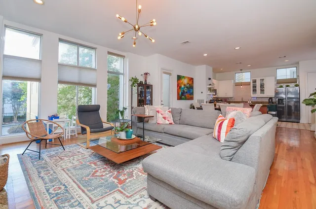 a living room with furniture kitchen view and a large window