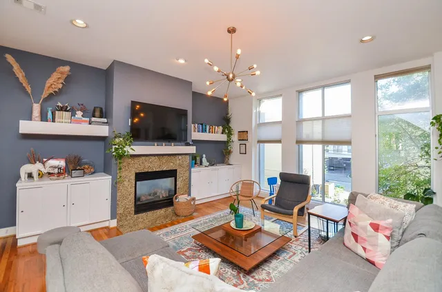 a living room with furniture a flat screen tv and a fireplace