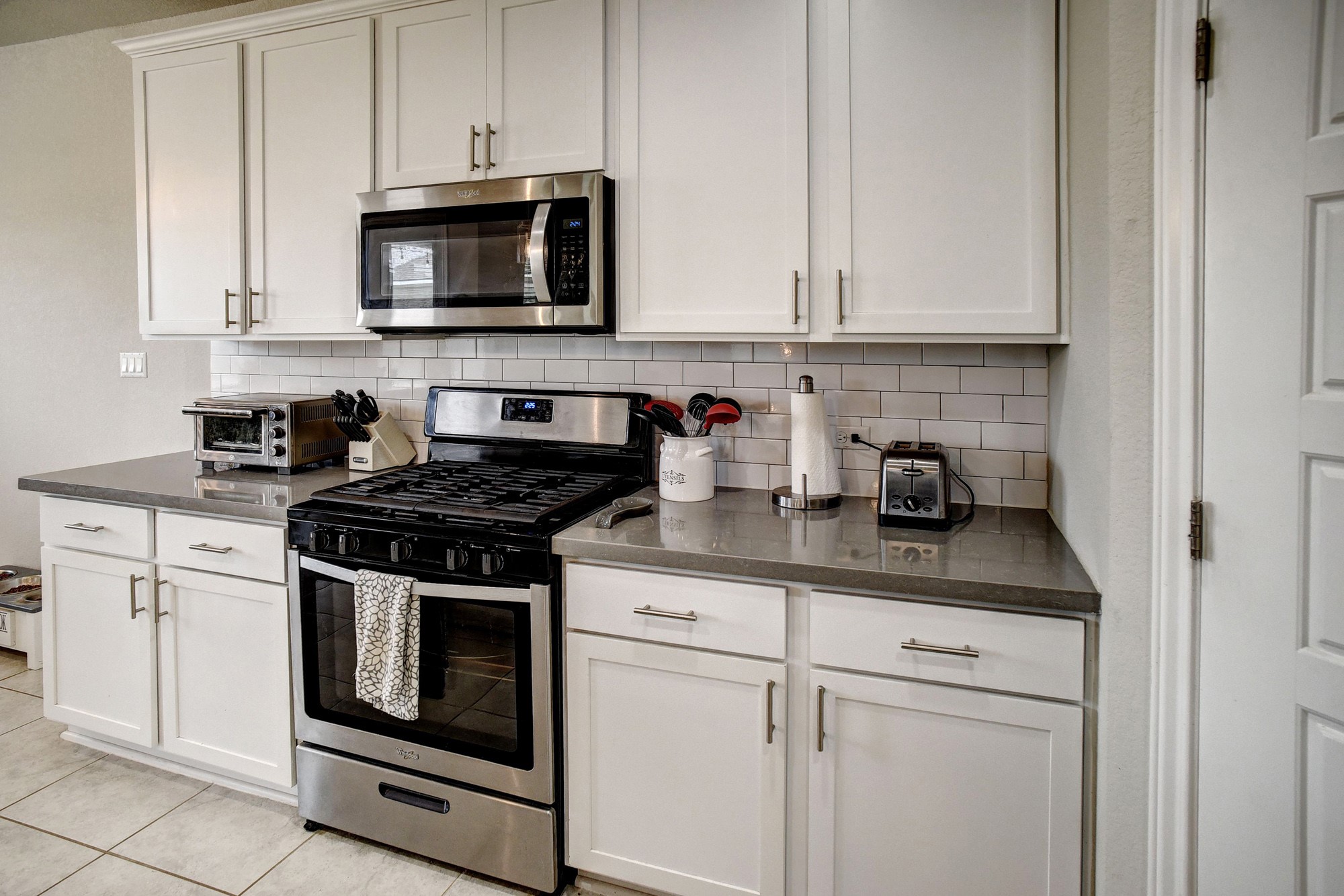 210 Cold Spg Loop, Unit 1 Bastrop, TX 78602 - Photo 13 of 40 a kitchen with white cabinets and black appliances