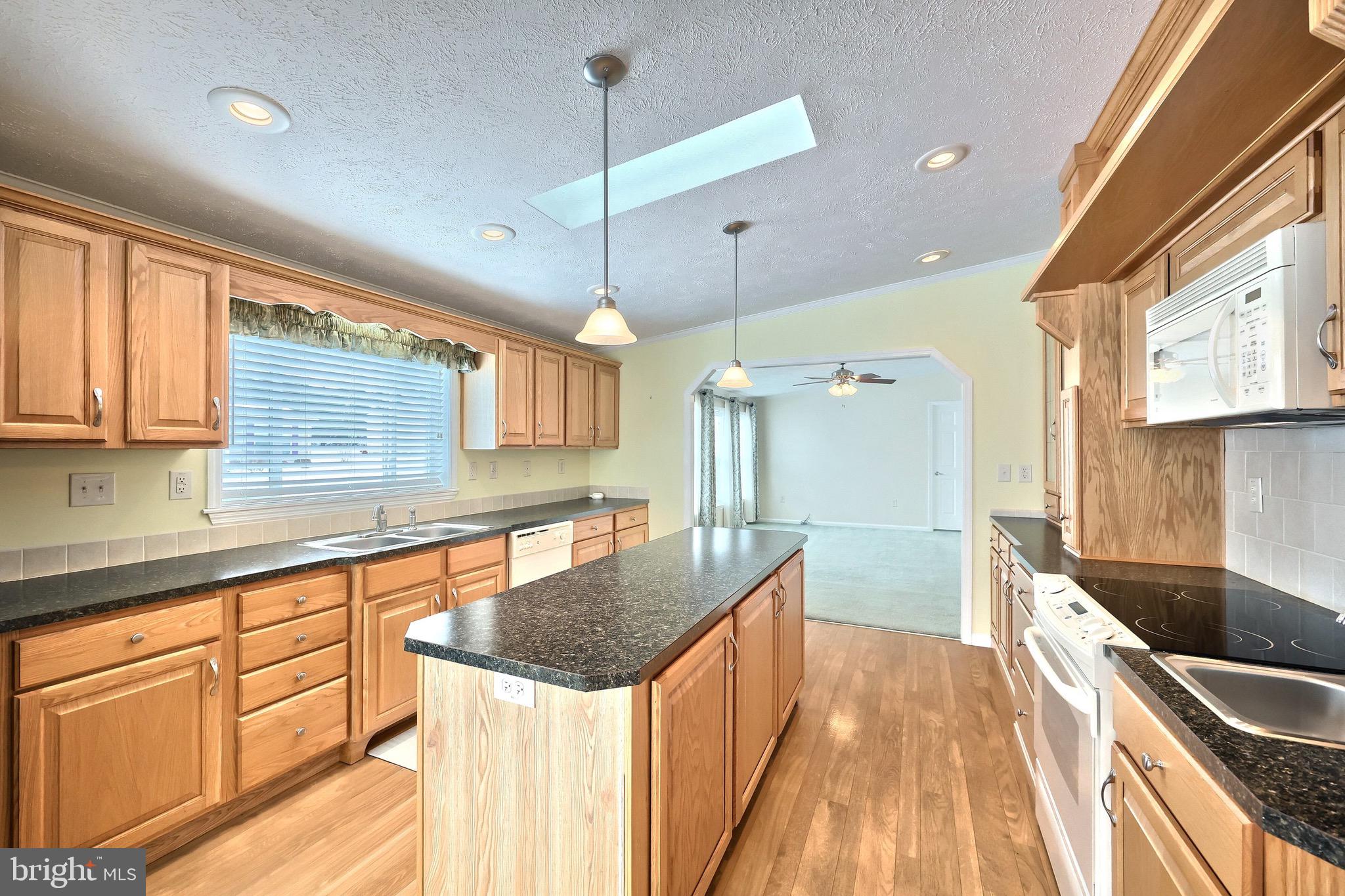267 Runaway Road Abbottstown, PA 17301 - Photo 12 of 38 a kitchen with stainless steel appliances granite countertop a sink a stove and a wooden floors