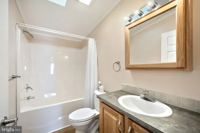 a bathroom with a granite countertop sink a mirror and a bathtub