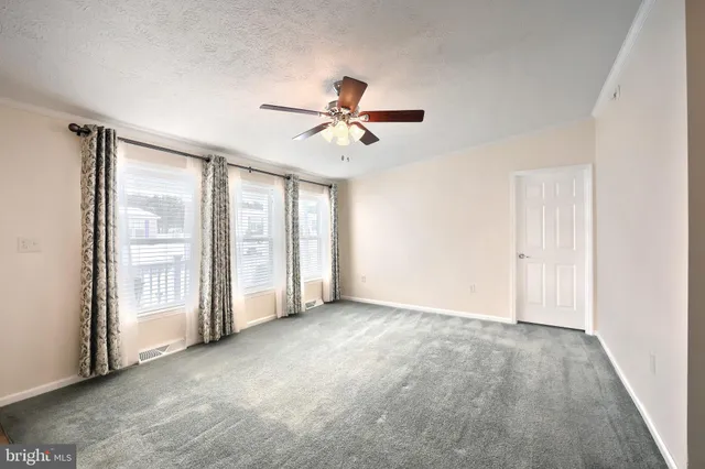 a view of a livingroom with a ceiling fan and kitchen view