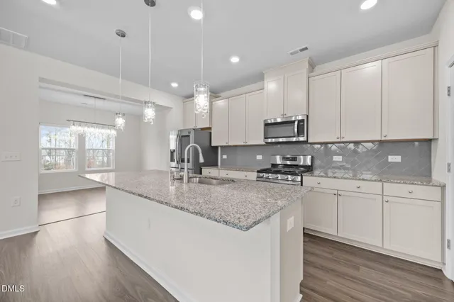 a kitchen with stainless steel appliances granite countertop a sink stove and cabinets