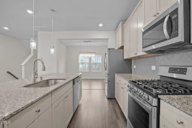 a kitchen with stainless steel appliances granite countertop a sink stove and cabinets