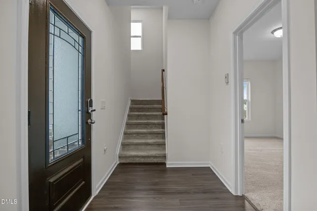 a view of a hallway with wooden floor and entryway