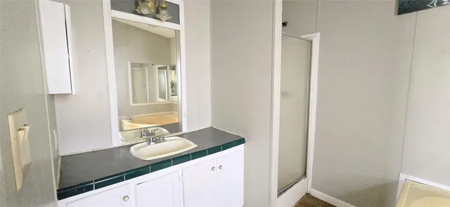 a bathroom with a granite countertop sink and a mirror