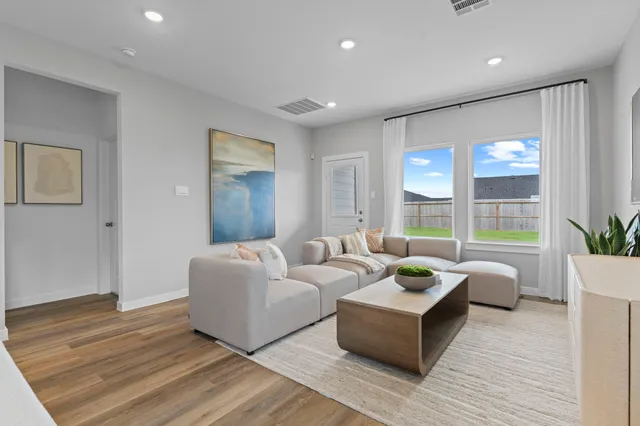 a living room with furniture and wooden floor