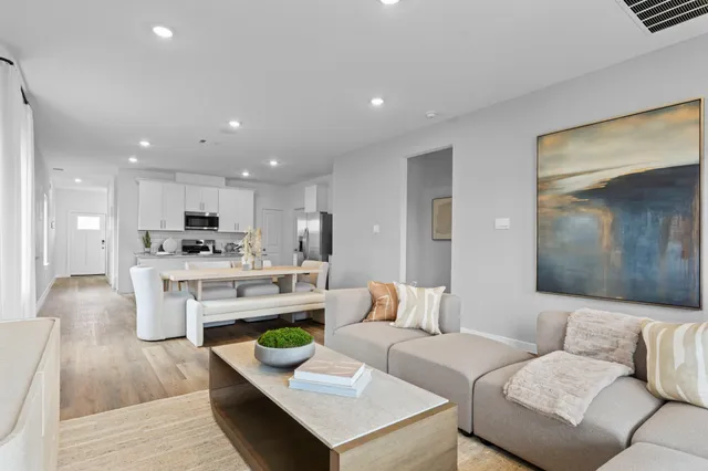 a living room with furniture and kitchen view