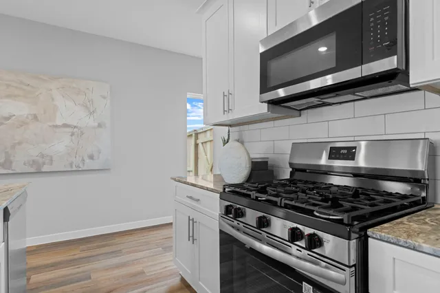 a stove top oven sitting inside of a kitchen